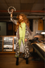 Woman in a luxury leopard print long robe pajamas and lime punch green luxury pajama set standing in a music studio.