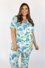 A woman wearing a short sleeve and cropped pant pajama set with a hydrangea bloom print.