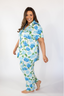 A woman wearing a short sleeve and cropped pant pajama set with a hydrangea bloom print.