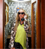 Woman in a telephone booth wearing a luxury leopard print pajama set and sunglasses.