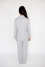 Person wearing a light gray pajama set on a white background