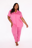 Woman wearing a pink pajama set on a white background