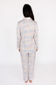 Person wearing a light blue and pink patterned pajama set on a white background