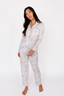 Woman wearing a light blue and white patterned pajama set on a white background