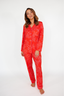 Woman wearing a red floral pajama set on a white background