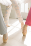 Ballet dancers in pointe shoes on a white floor