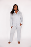 Woman wearing a light gray pajama set on a white background