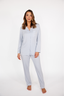 Woman wearing light blue pajama set on a white background