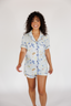 Woman wearing a patterned pajama set on a plain background
