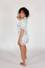 Woman wearing a light blue floral pajama set on a white background