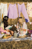 Mallory Ervin having a picnic in a field with a friend. They are both wearing spring modal pajama sets.