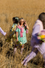 Mallory Ervin standing in a field wearing a modal pajama set holding a bouquet of flowers.