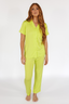 Woman wearing a lime punch green luxury pajama set on a white background