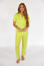 Woman wearing a lime punch green luxury pajama set on a white background