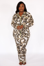Woman wearing a luxury leopard print pajama set with lime punch colored piping on a white background