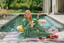 Woman in a green pajama set by a pool with snacks and drinks
