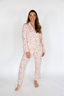 Woman wearing a pink pajama set with a white background