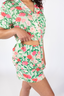 A woman wearing a short sleeve and short pajama set with a peony blossom print.