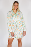 Woman wearing a floral patterned nightshirt on a plain background