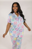 A woman wearing a short sleeve and cropped pant pajama set with a Sweetheart Cakes in Sky print.