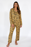 Woman wearing a luxury tiger stripe pajama set with bows incorporated into the stripes on a white background