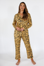 Woman wearing a luxury tiger stripe pajama set with bows incorporated into the stripes on a white background