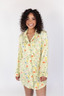 A woman smiling, wearing a green sleep dress with a floral wildflowers pattern.