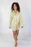 A woman smiling, wearing a green sleep dress with a floral wildflowers pattern.