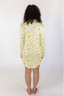 A woman smiling, wearing a green sleep dress with a floral wildflowers pattern.