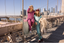 Two women posing on the Brooklyn Bridge with city skyline in the background