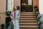 Woman in a plaid coat standing on a decorated staircase with Christmas decorations.