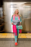 Woman holding a newspaper in a subway station with a blurred train in the background