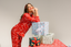 Woman in red pajama set with gift boxes on a table