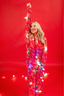 Person wearing festive pajamas with lights against a red background