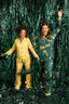 Two women in festive pajamas standing in a shower of tinsel.